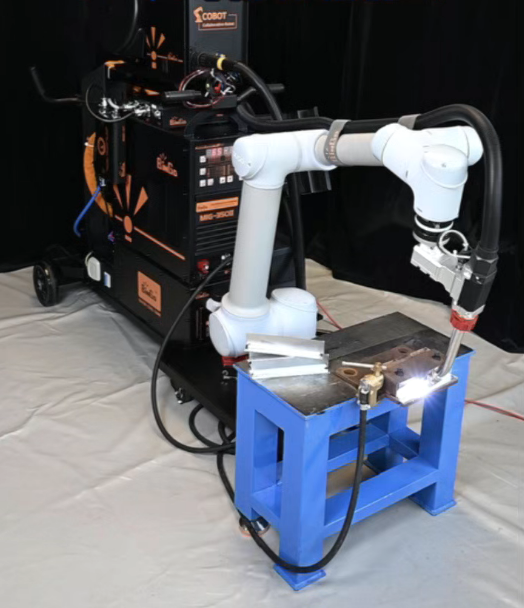 Mobile cobot welding cart in operation, collaborative robot welding a metal workpiece with visible arc flash