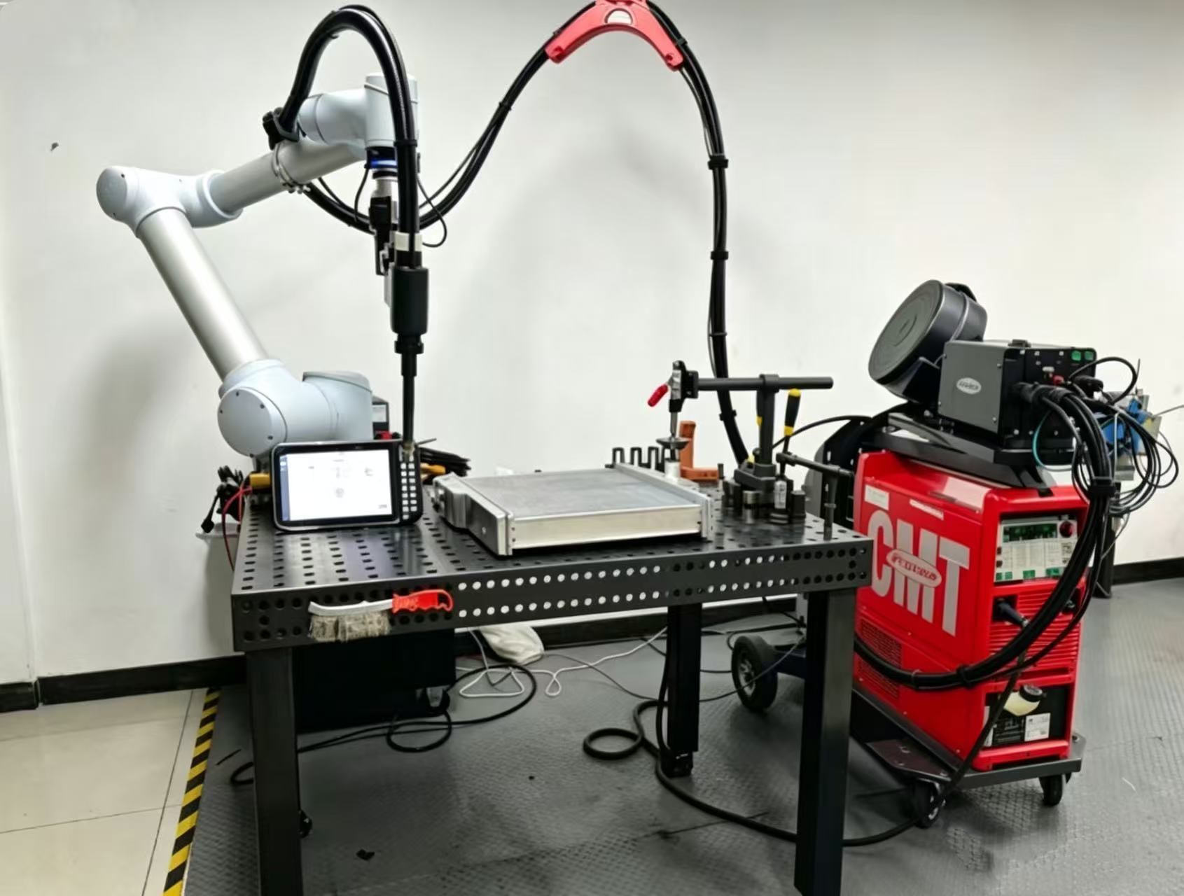 Collaborative robot welding workstation with welding table, power source, torch and wire feeder