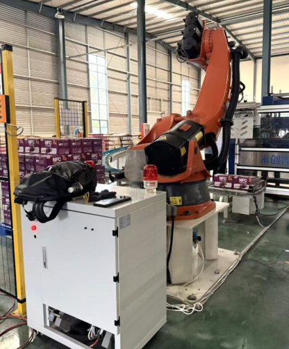 Retrofit control cabinet installed alongside a handling robot on the shop floor